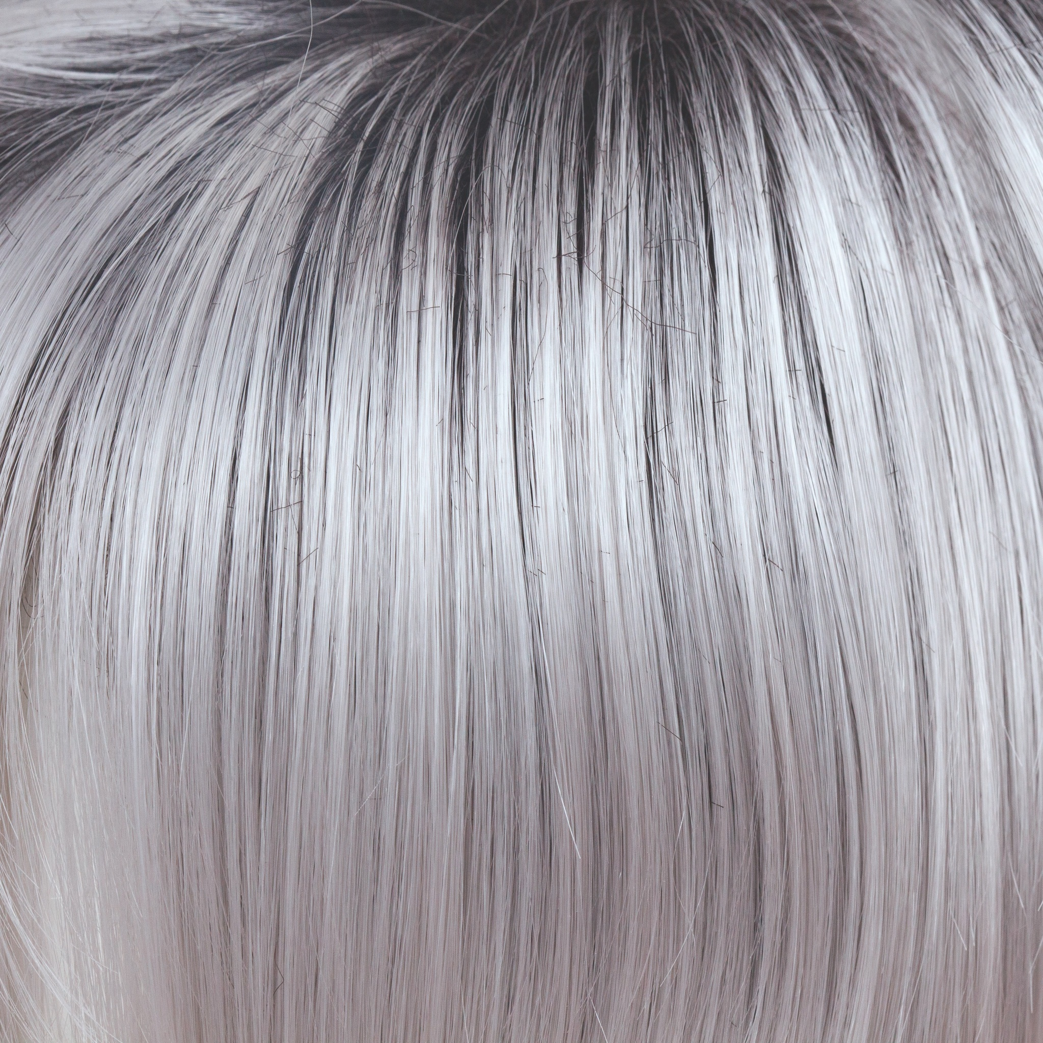 Illumina-R  -  A truly stunning color! This striking iridescent white gives off hues of silver and pales purples. The dark brown root has an appearance of natural regrowth. Illumina-R is fashion forward and toned to perfection.